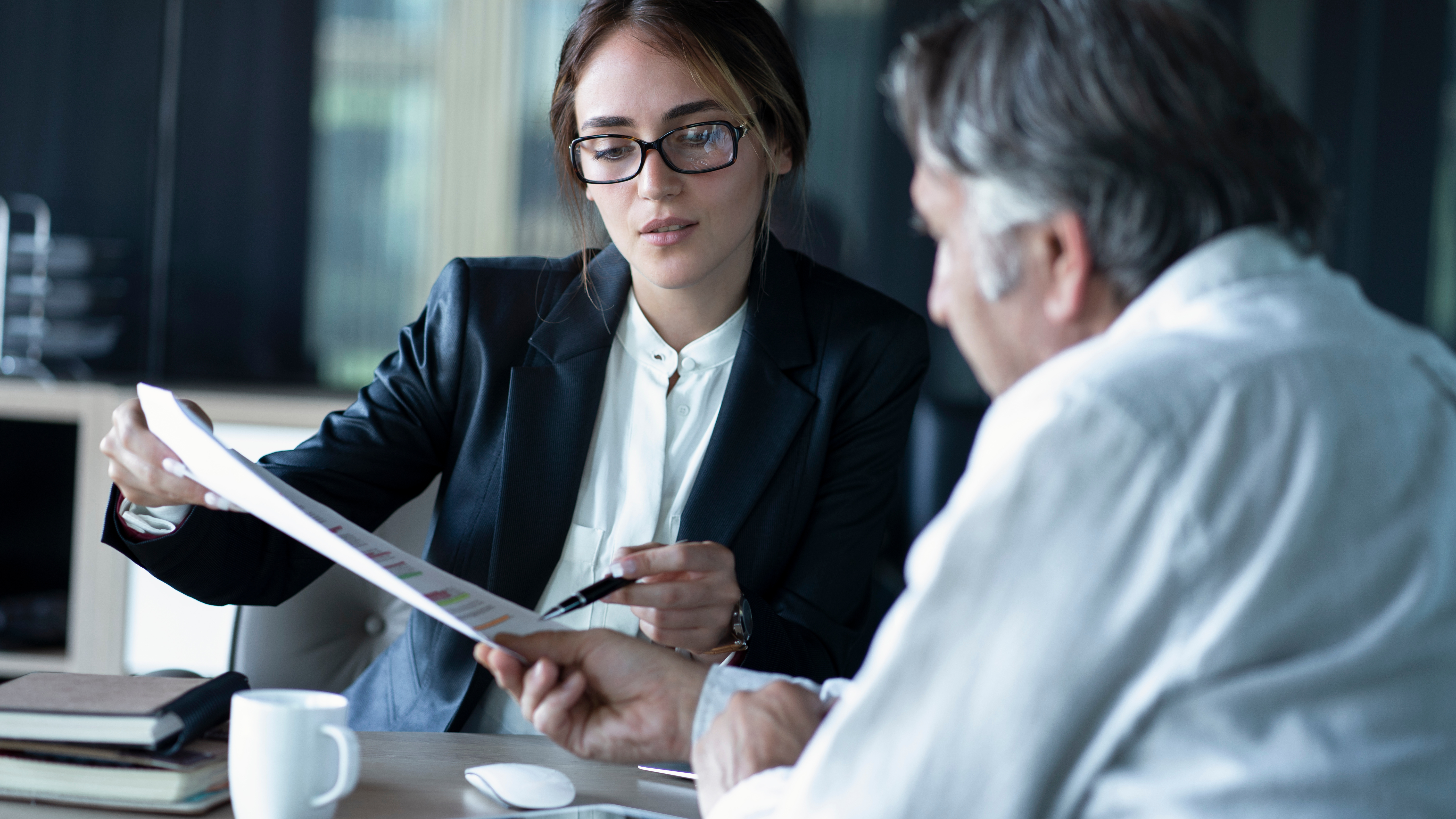 Financial professional sitting at a table and looking over documents.