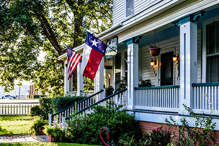 front porch with Texas state flag and American flag