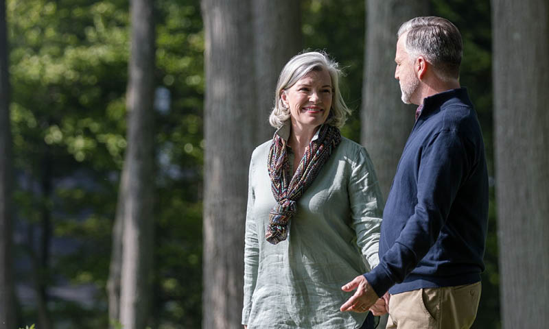 Older man and woman, walking through forest together