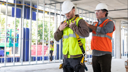 image of supervisor inspecting fall protection harness on a worker
